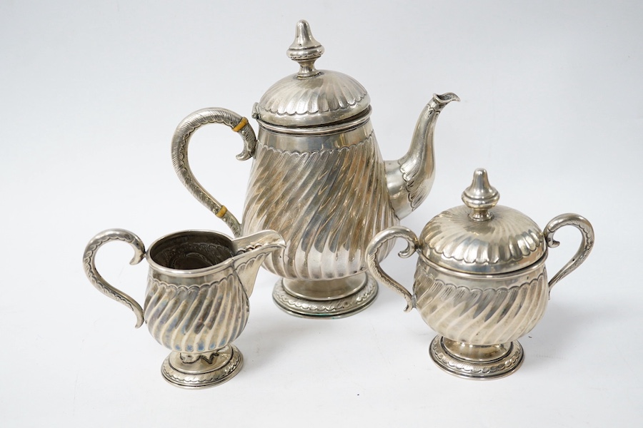 A German 800 standard white metal three piece pedestal tea set, with horn insulators and spiral fluted decoration, gross weight 15.5oz. Condition - poor